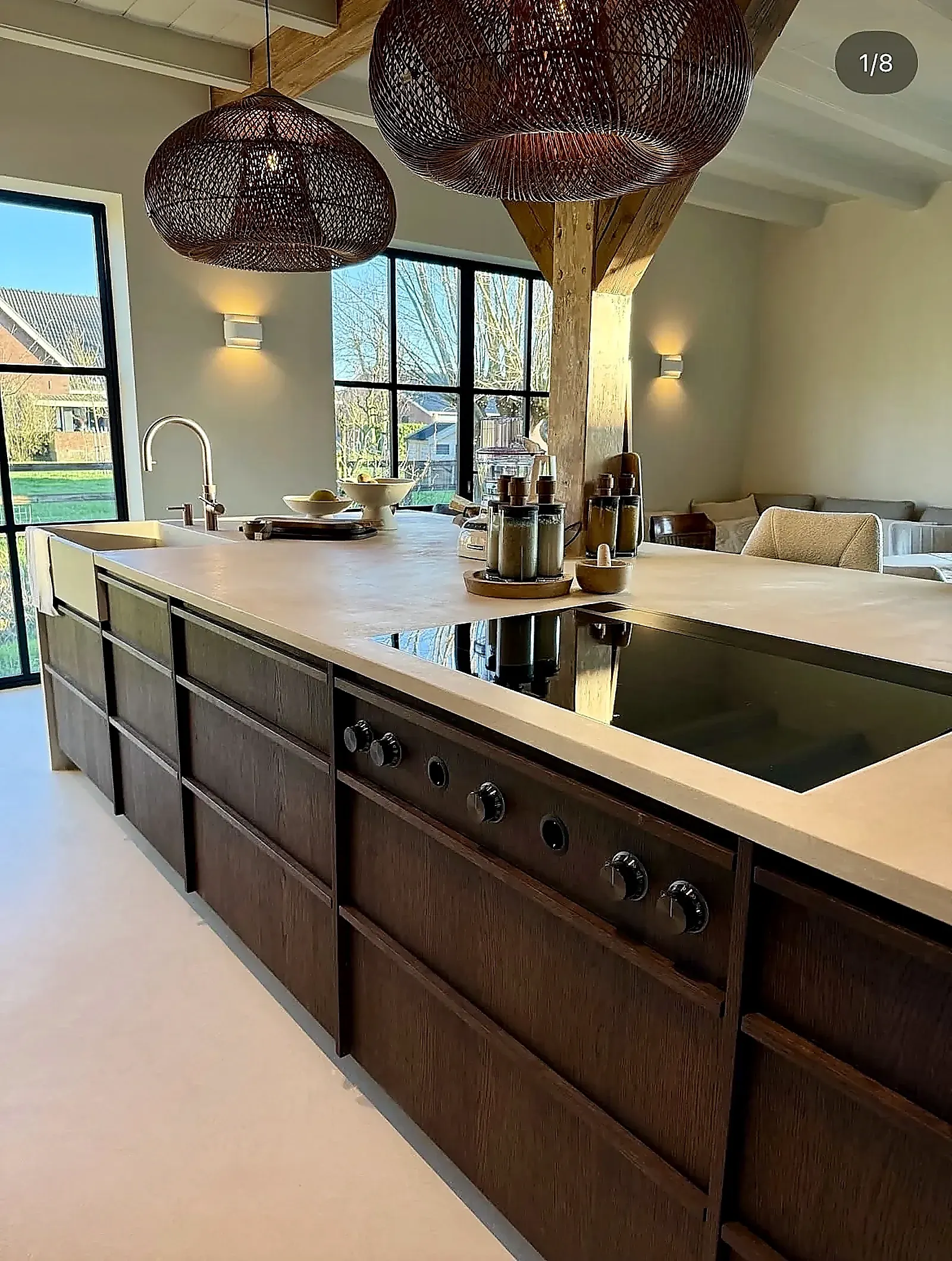 Microcement aanrechtblad met kookplaat, houten balken en rieten lampen in woonboerderij Harmelen